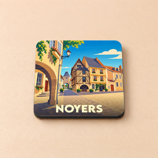 Dessous de verre souvenir de la ville de Noyers avec une illustration stylisée d'une place médiévale.