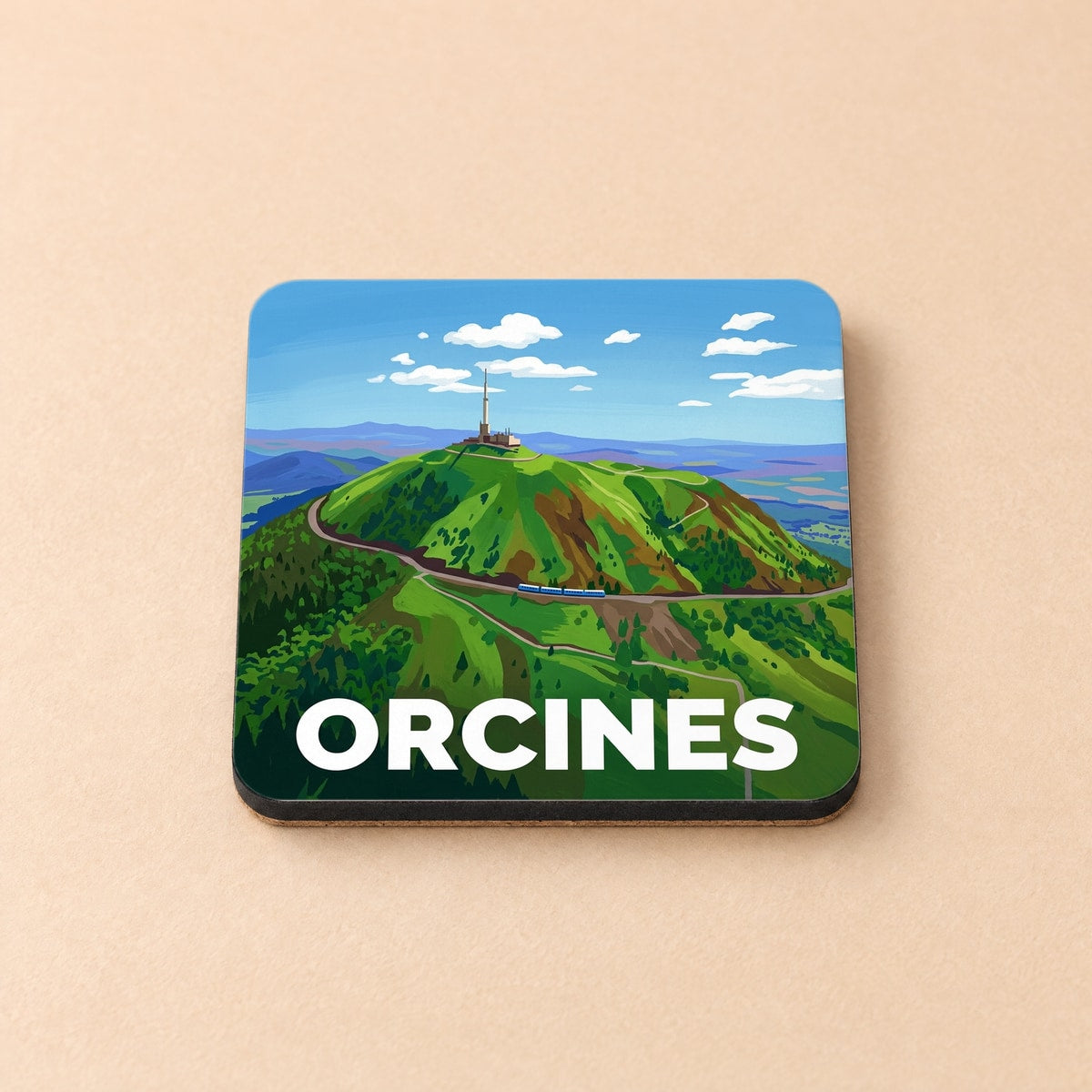 Dessous de verre souvenir de la ville d'Orcines avec une illustration stylisée du Puy de Dôme.