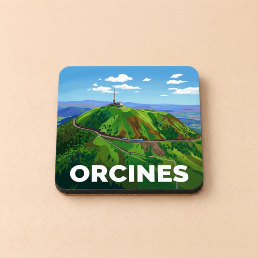 Dessous de verre souvenir de la ville d'Orcines avec une illustration stylisée du Puy de Dôme.