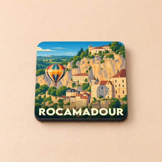 Dessous de verre souvenir de Rocamadour illustré d'un paysage stylisé de la cité médiévale et d'une montgolfière.
