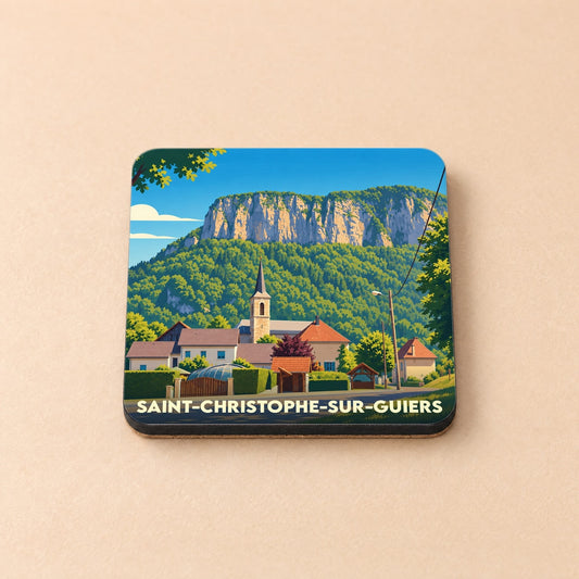 Dessous de verre souvenir de la ville de Saint-Christophe-sur-Guiers avec une illustration stylisée du village et de sa montagne.