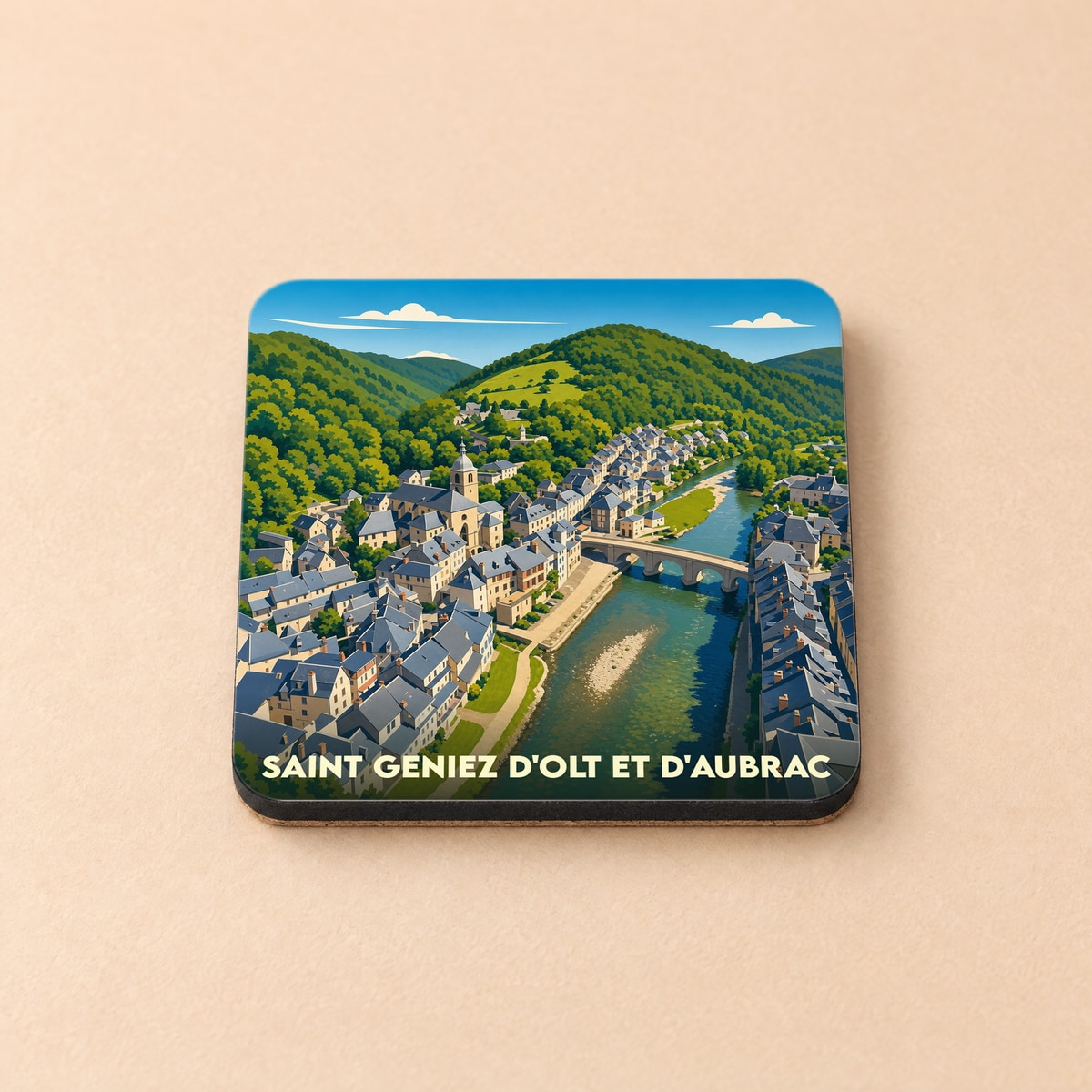 Dessous de verre souvenir de la ville de Saint-Geniez-d'Olt-et-d'Aubrac avec une illustration stylisée.