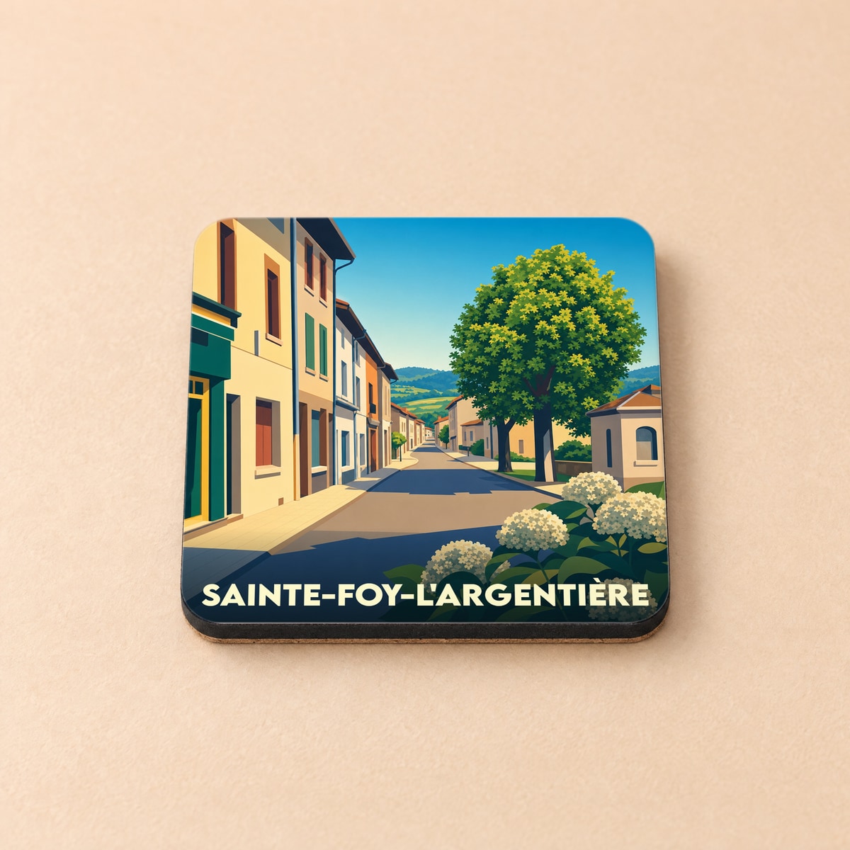 Dessous de verre souvenir de la ville de Sainte-Foy-l'Argentière avec une illustration stylisée d'une rue ensoleillée.