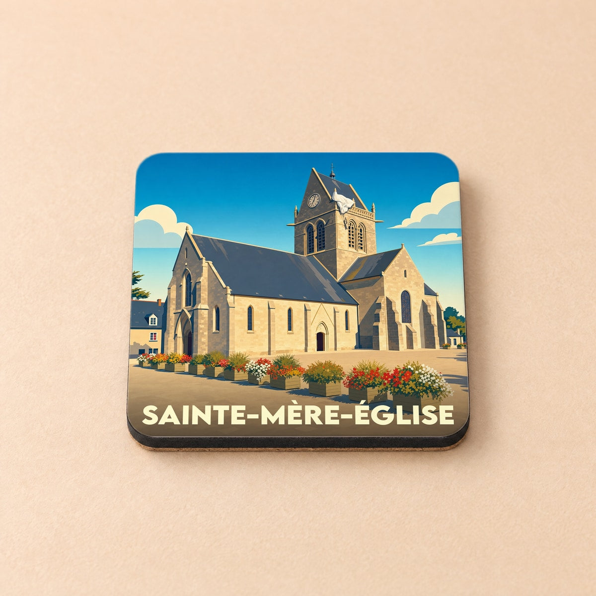 Dessous de verre souvenir de la ville de Sainte-Mère-Église illustrant son église avec le célèbre parachutiste accroché au clocher.