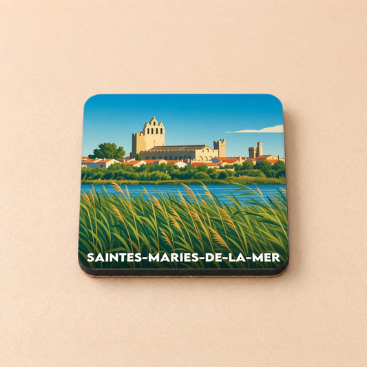 Dessous de verre souvenir de Saintes-Maries-de-la-Mer illustré par une vue stylisée de l'église fortifiée bordée de roseaux.