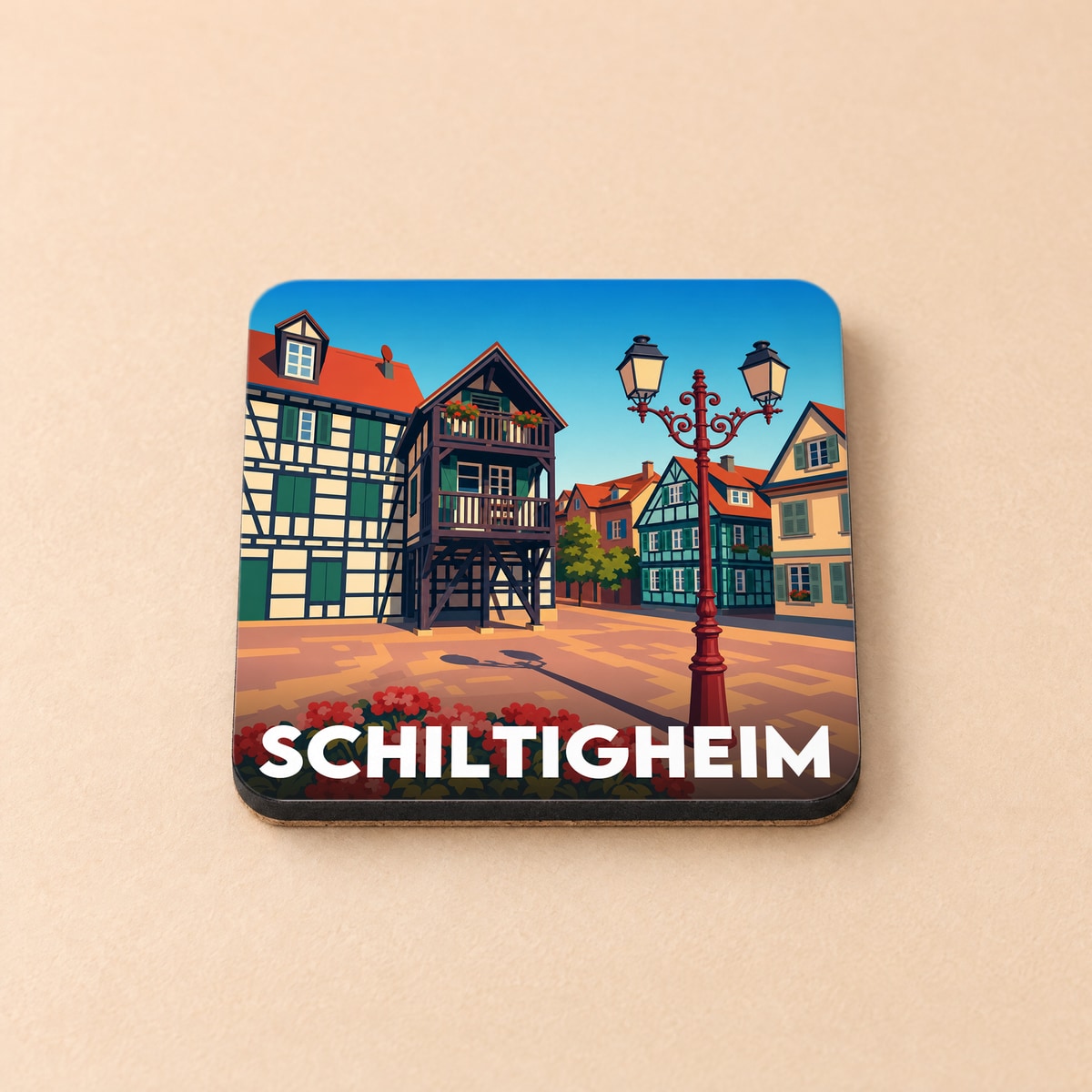 Dessous de verre souvenir de la ville de Schiltigheim avec une illustration stylisée de maisons à colombages.