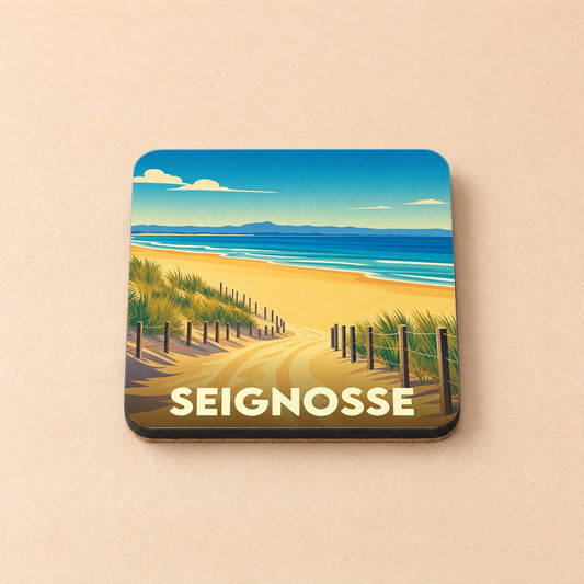 Dessous de verre souvenir de la ville de Seignosse avec une illustration stylisée d'un chemin menant à la plage.