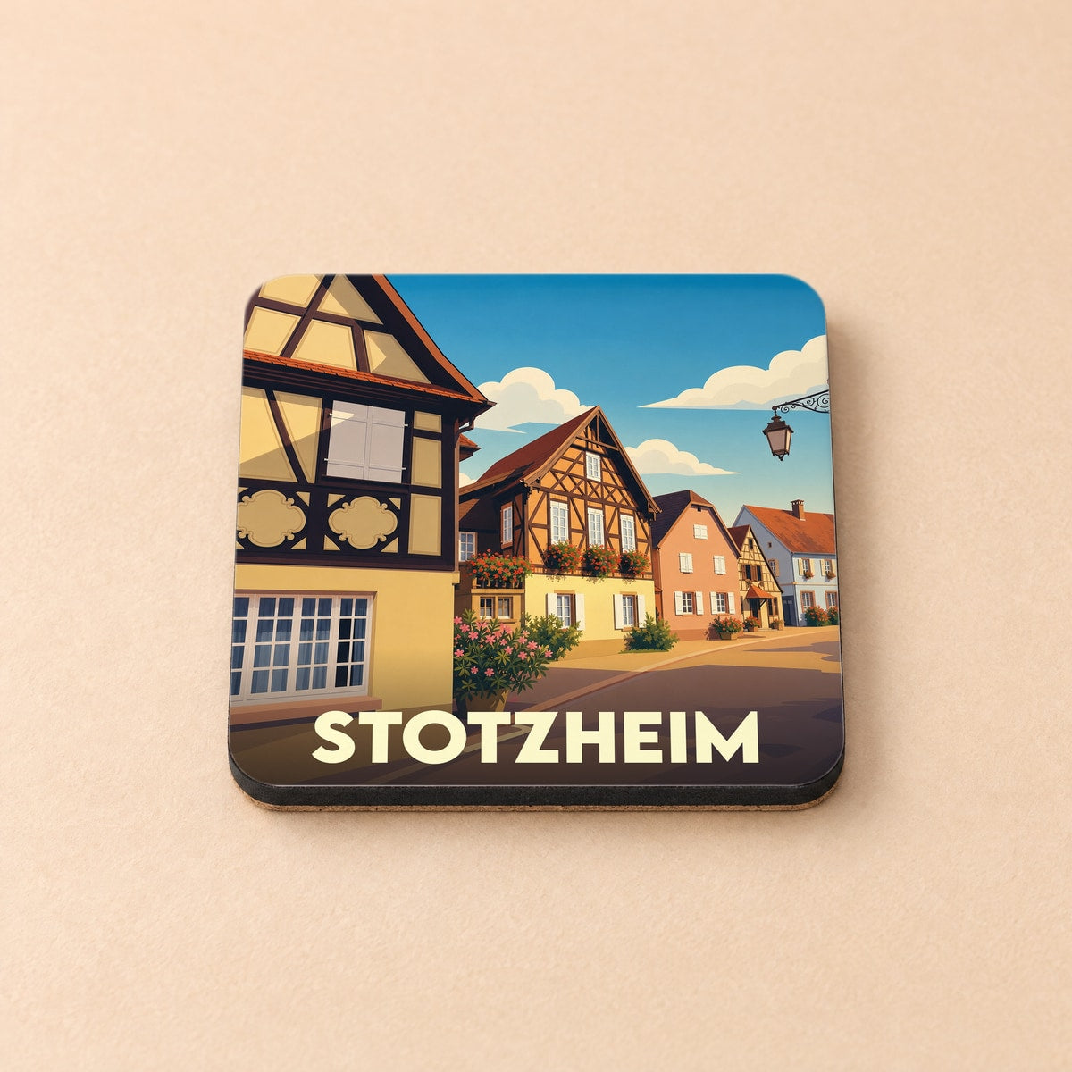 Dessous de verre souvenir de la ville de Stotzheim orné d'une illustration stylisée de maisons à colombages.