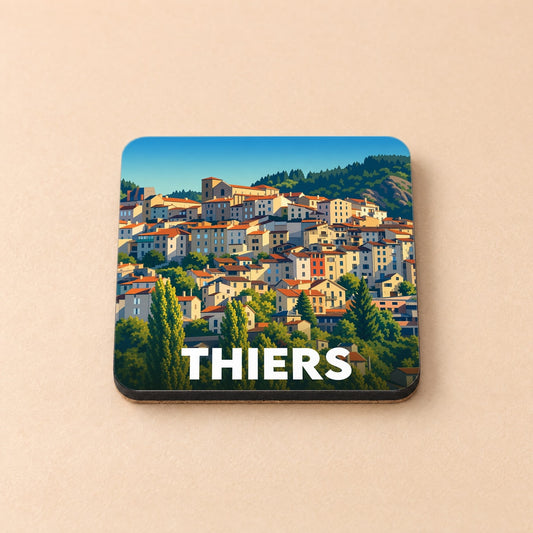 Dessous de verre souvenir de la ville de Thiers avec une illustration stylisée d'un village à flanc de colline.