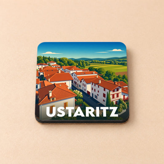 Dessous de verre souvenir de la ville d'Ustaritz avec une illustration stylisée de maisons basques et de paysages vallonnés.