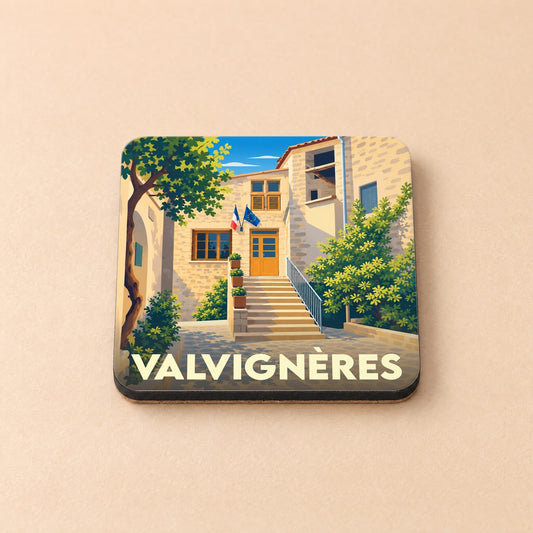 Dessous de verre souvenir de la ville de Valvignères avec une illustration stylisée d'un bâtiment en pierre.