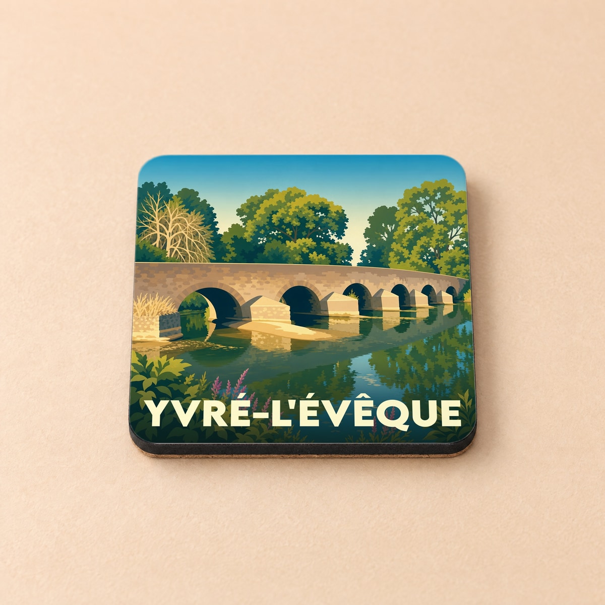 Dessous de verre souvenir de la ville d'Yvré-l'Évêque avec une illustration stylisée d'un pont en pierre.