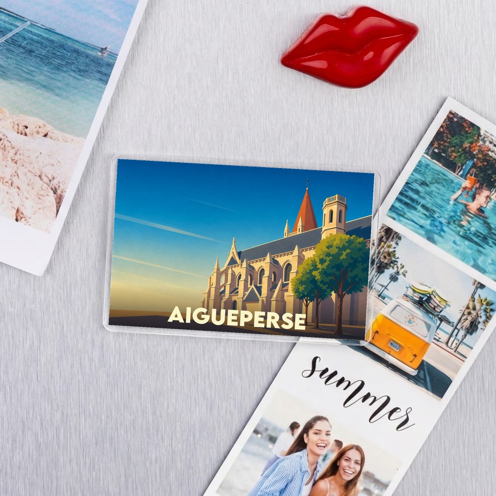 Magnet souvenir de la ville d'Aigueperse avec une illustration stylisée d'une église au coucher du soleil.