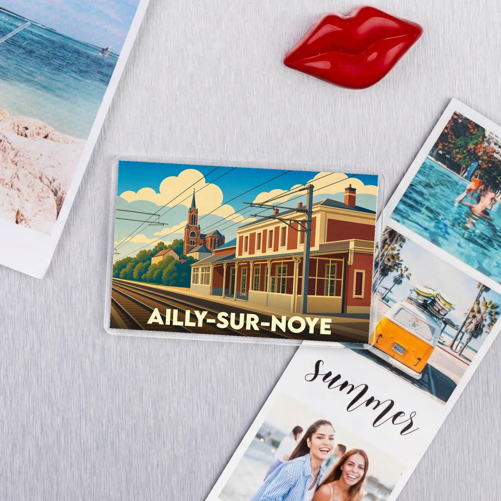 Magnet souvenir de la ville d'Ailly-sur-Noye avec une illustration stylisée de sa gare et de son église.