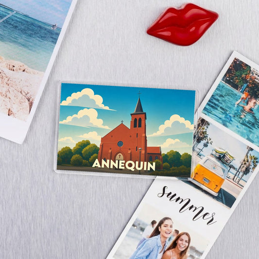 Magnet souvenir de la ville d'Annequin avec une illustration stylisée de son église sous un ciel nuageux.