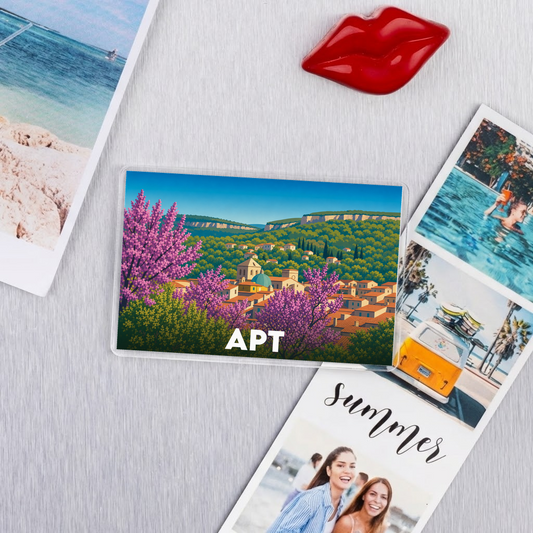 Magnet souvenir de la ville de Apt avec une illustration stylisée de son paysage urbain et fleuri.