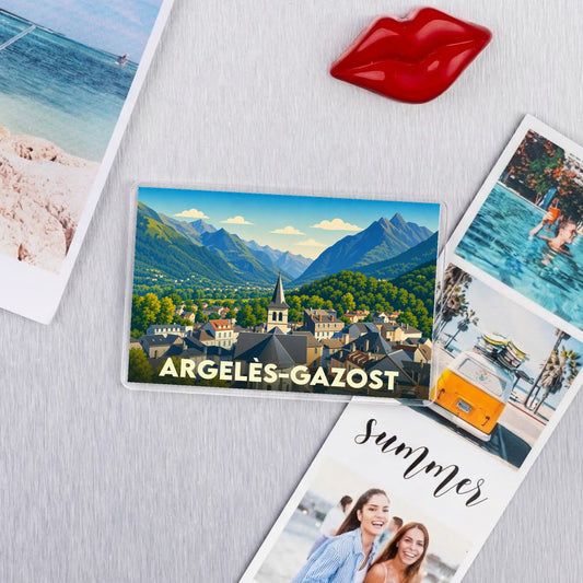 Magnet souvenir de la ville d'Argelès-Gazost avec une illustration de paysage de montagne.