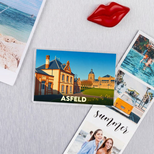 Magnet souvenir de la ville d'Asfeld avec une illustration stylisée de ses bâtiments emblématiques.