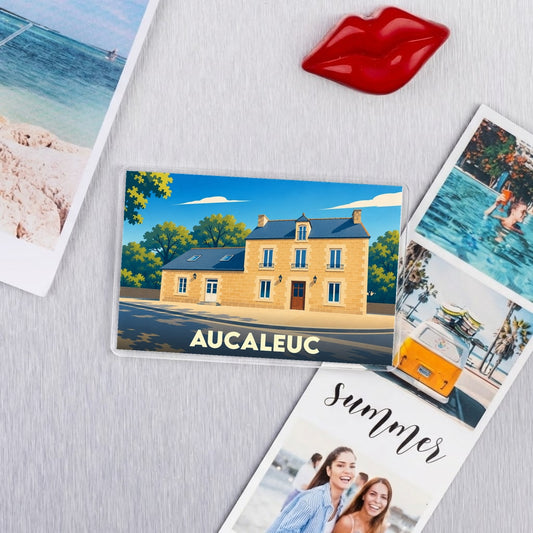 Magnet souvenir de la ville d'Aucaleuc avec une illustration stylisée d'une maison traditionnelle bretonne.