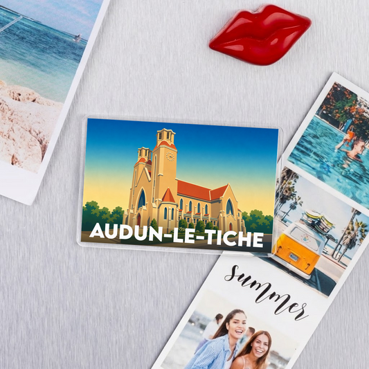 Magnet souvenir de la ville d'Audun-le-Tiche avec une illustration stylisée d'une église.