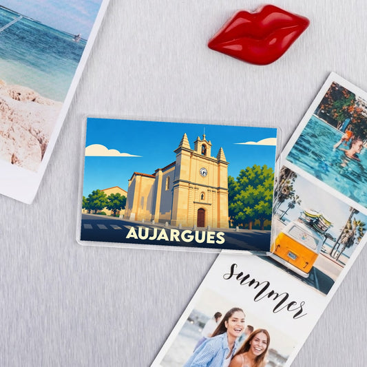 Magnet souvenir de la ville d'Aujargues illustrant son église sous un ciel bleu.