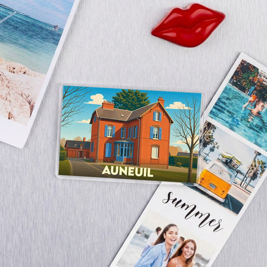 Magnet souvenir de la ville d'Auneuil avec une illustration stylisée d'une maison en briques rouges.