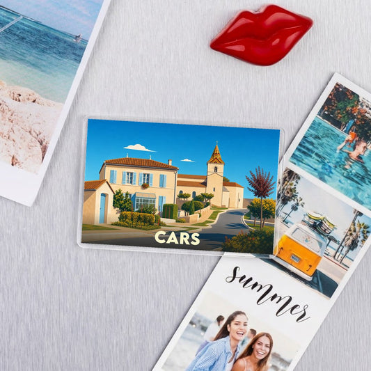 Magnet souvenir de la ville de Cars illustrant un paysage de village sous un ciel bleu.
