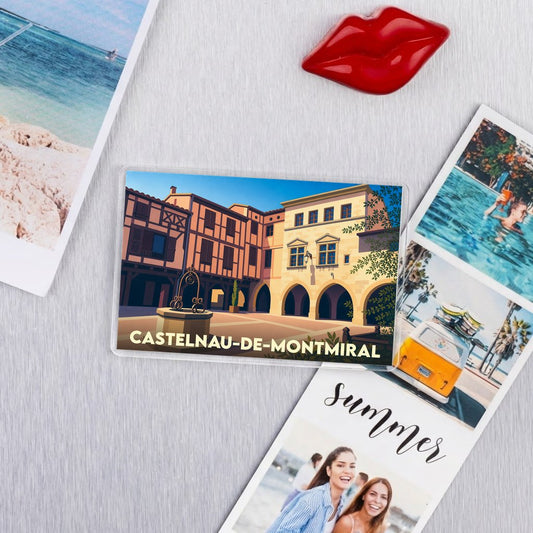 Magnet souvenir de la ville de Castelnau-de-Montmiral avec une illustration stylisée de sa place centrale.
