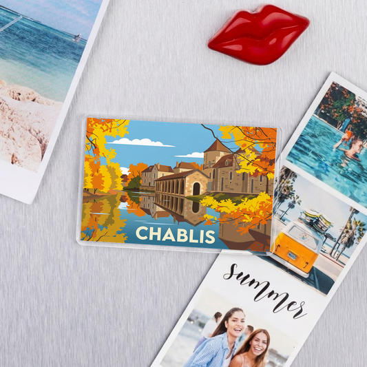Magnet souvenir de la ville de Chablis avec une illustration stylisée de ses bâtiments au bord de l'eau.