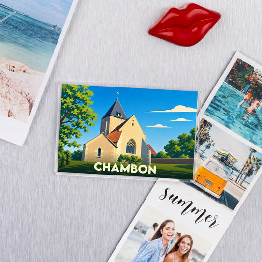 Magnet souvenir de la ville de Chambon avec une illustration stylisée de son église sous un ciel bleu.