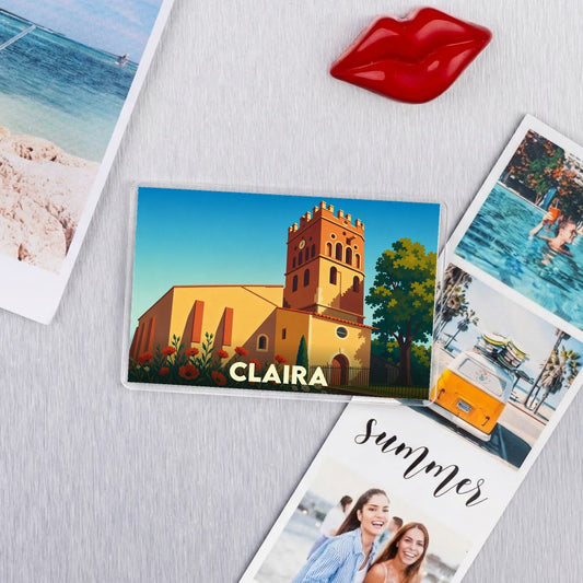 Magnet souvenir de la ville de Claira illustré d'un bâtiment historique et d'une église sous un ciel bleu.