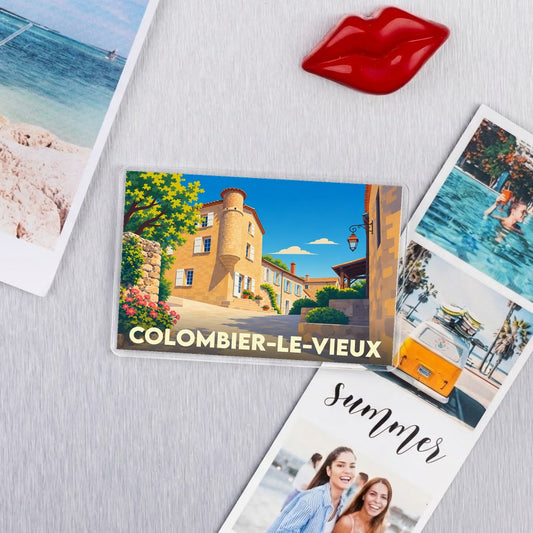 Magnet souvenir de Colombier-le-Vieux orné d'une illustration stylisée du village sous un ciel azur.