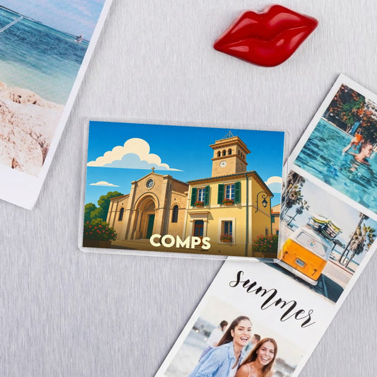 Magnet souvenir de la ville de Comps avec une illustration stylisée d'une église et de son clocher sous un ciel ensoleillé.