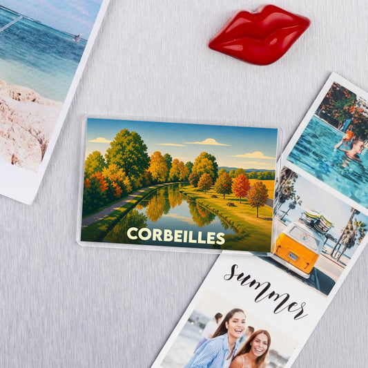 Magnet souvenir de la ville de Corbeilles illustrant un canal bordé d'arbres aux couleurs automnales.