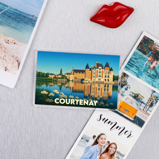 Magnet souvenir de la ville de Courtenay avec une illustration stylisée de son château se reflétant dans l'eau.