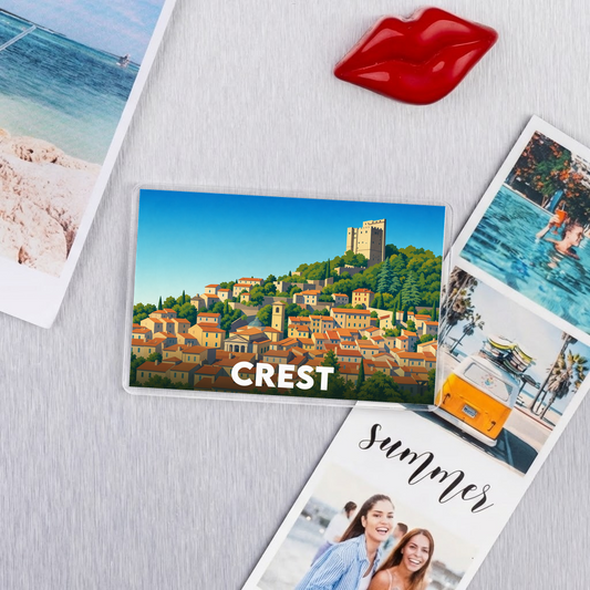 Magnet souvenir de la ville de Crest avec une illustration stylisée de ses maisons et de sa tour.