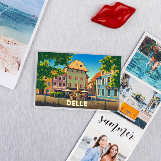 Magnet souvenir de la ville de Delle avec une illustration stylisée et colorée de ses bâtiments.