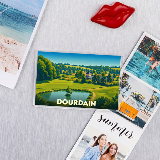 Magnet souvenir de la ville de Dourdain avec une illustration de paysage champêtre.