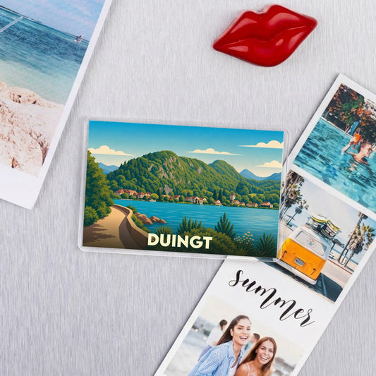 Magnet souvenir de la ville de Duingt avec une illustration stylisée d'un paysage lacustre et montagneux.