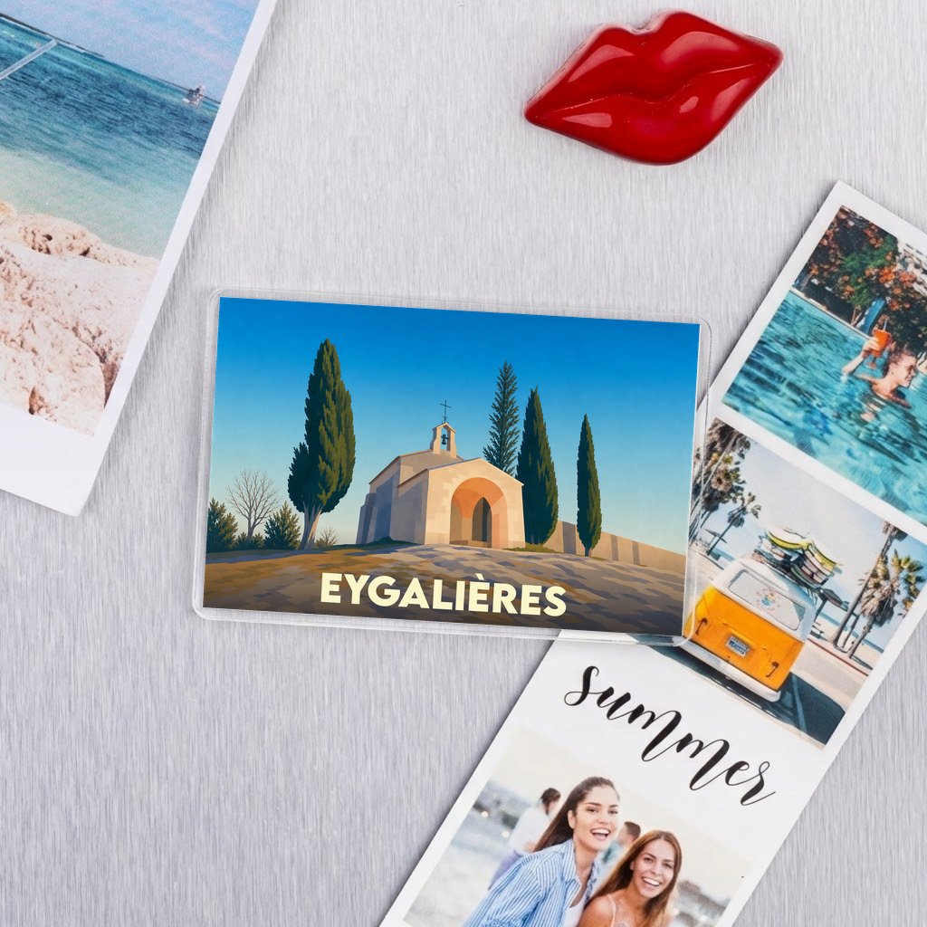 Magnet souvenir de la ville d'Eygalières avec une illustration stylisée d'une chapelle entourée de cyprès.