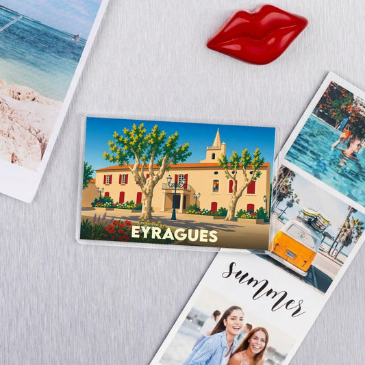 Magnet souvenir de la ville d'Eyragues avec une illustration stylisée d'un bâtiment provençal.