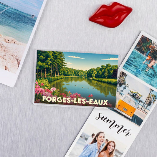 Magnet souvenir de la ville de Forges-les-Eaux avec une illustration stylisée d'un lac bordé de fleurs.
