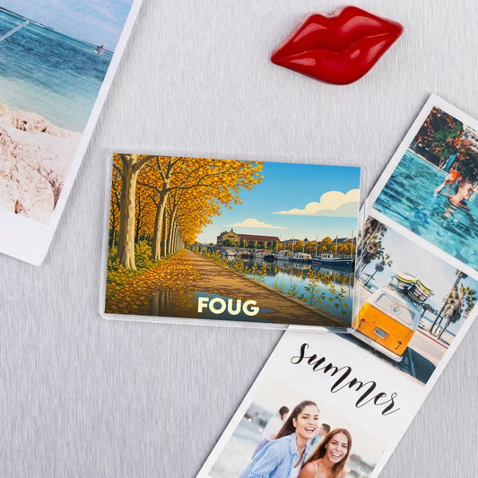 Magnet souvenir de la ville de Foug avec une illustration stylisée d'un canal bordé d'arbres en automne.