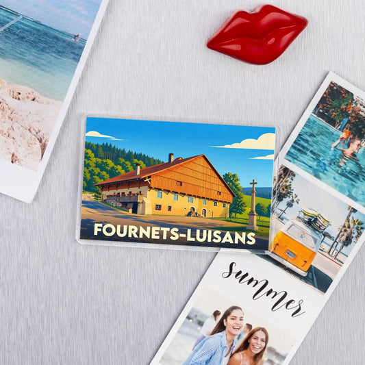 Magnet souvenir de la ville de Fournets-Luisans avec une illustration stylisée d'un chalet de montagne.