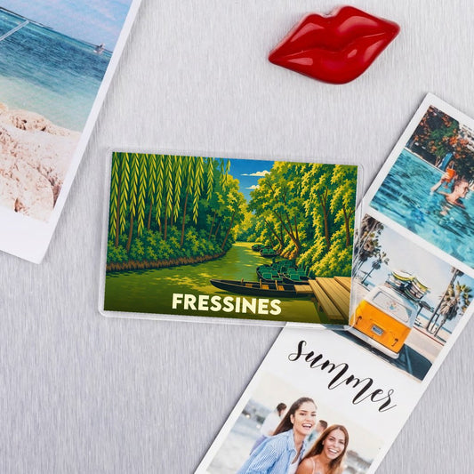 Magnet souvenir de la ville de Fressines avec une illustration stylisée d'un cours d'eau boisé.