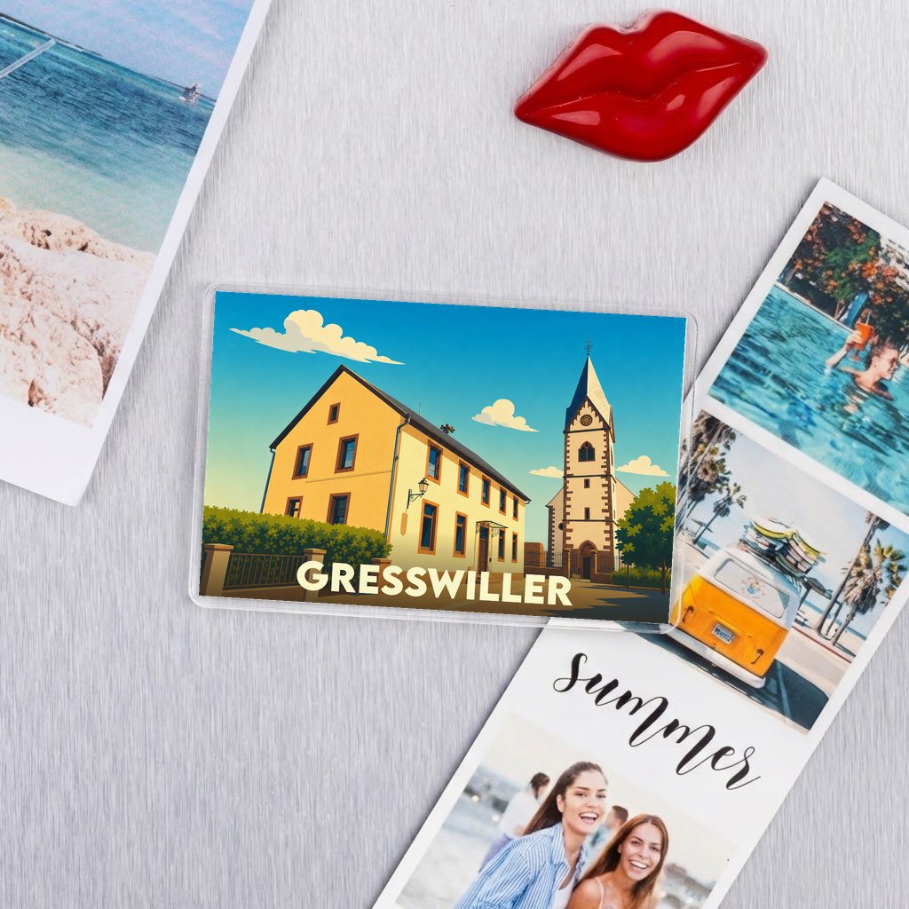 Magnet souvenir de la ville de Gresswiller avec une illustration stylisée de son église et d'un bâtiment traditionnel.
