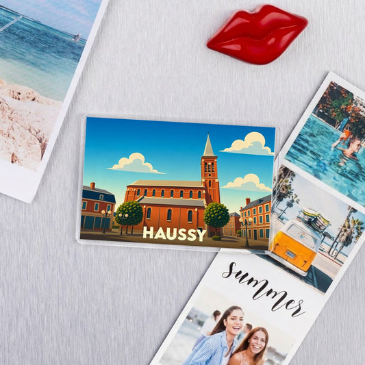 Magnet souvenir de la ville de Haussy avec une illustration stylisée de son église.