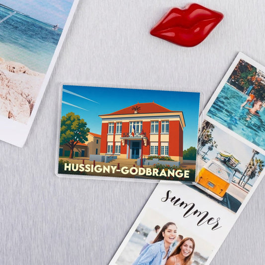 Magnet souvenir de la ville de Hussigny-Godbrange avec une illustration stylisée de sa mairie.