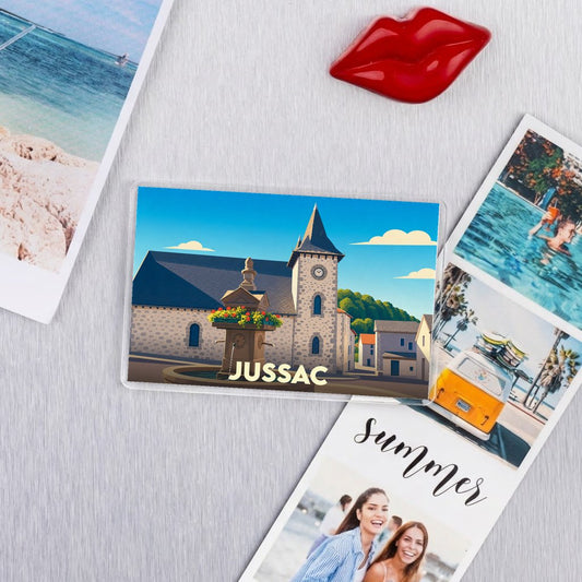 Magnet souvenir de la ville de Jussac avec une illustration stylisée.
