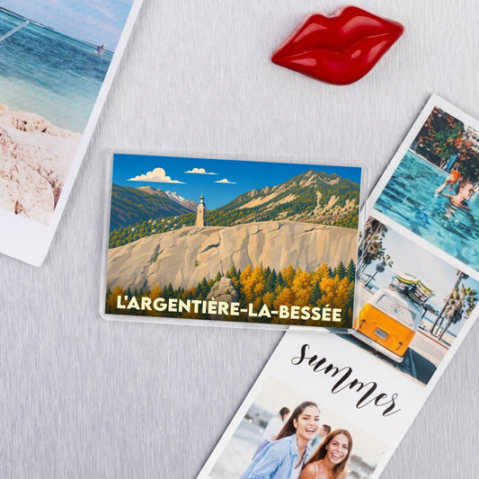 Magnet souvenir de la ville de L'Argentière-la-Bessée avec une illustration de paysage montagneux stylisé.